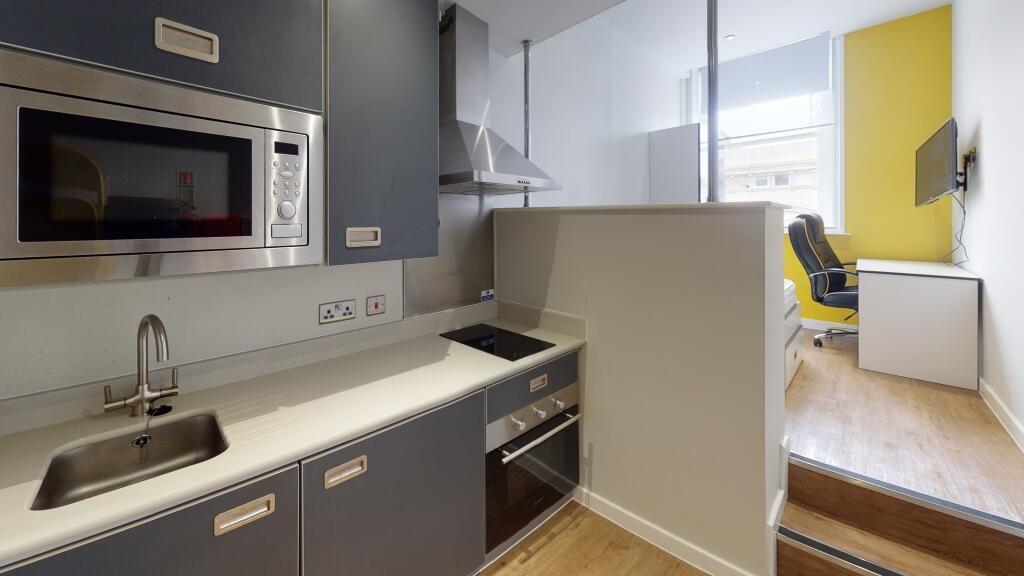 Modern kitchen area with sleek grey cabinetry, ...