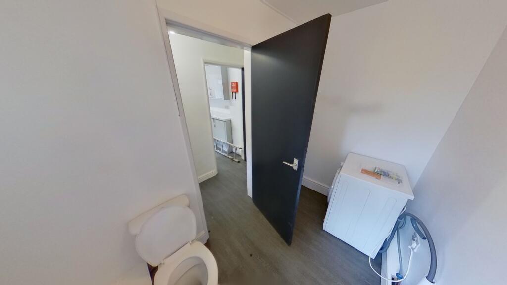A clean and simple single toilet room featuring...