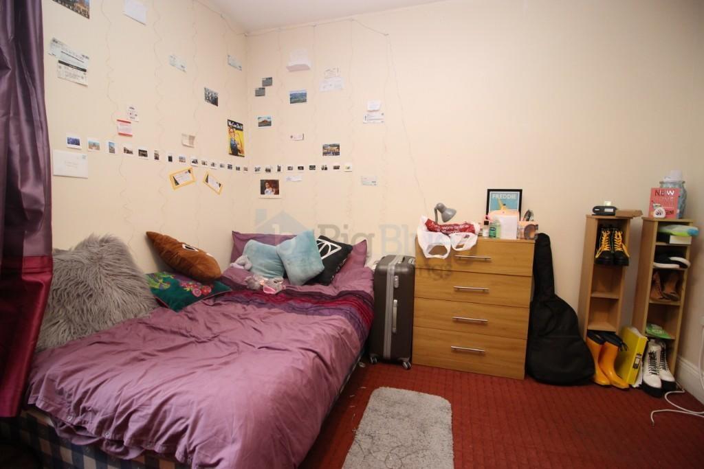 Cozy single bedroom featuring a comfortable bed...