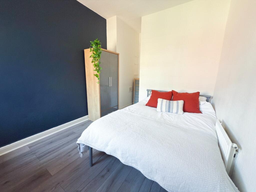 Bright, neatly styled bedroom with a comfortabl...