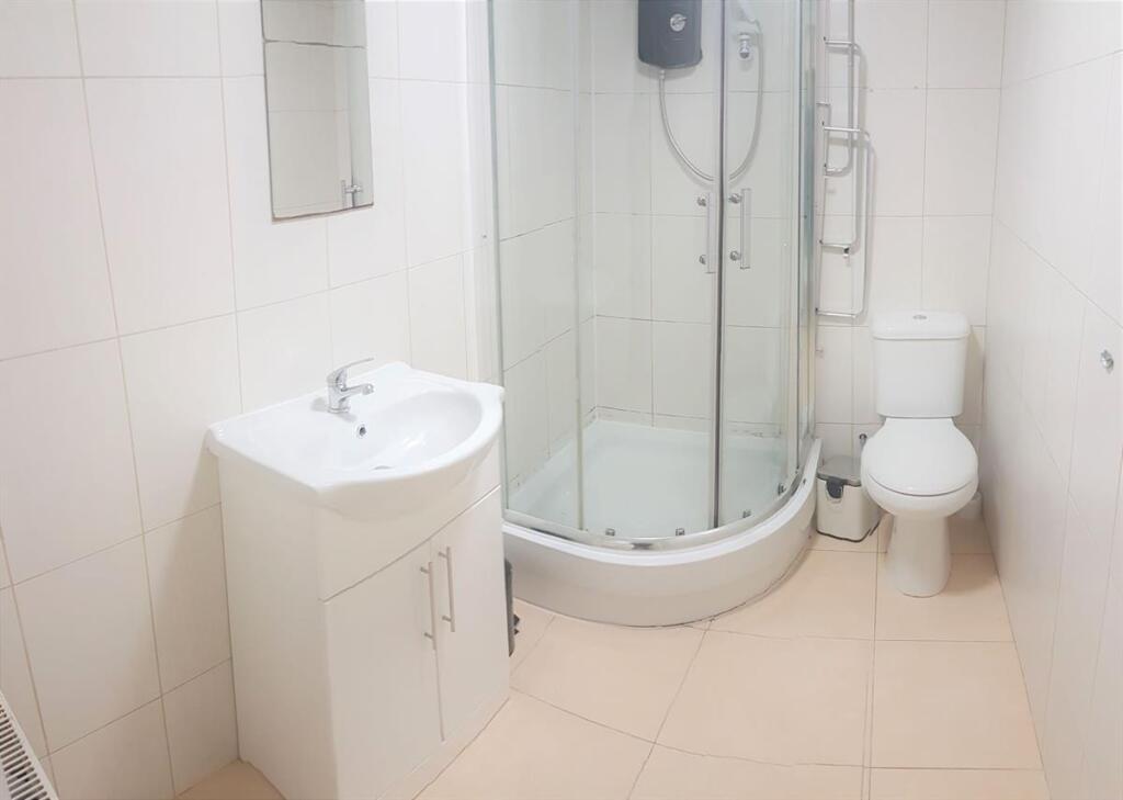 Bright, modern bathroom with a corner glass sho...