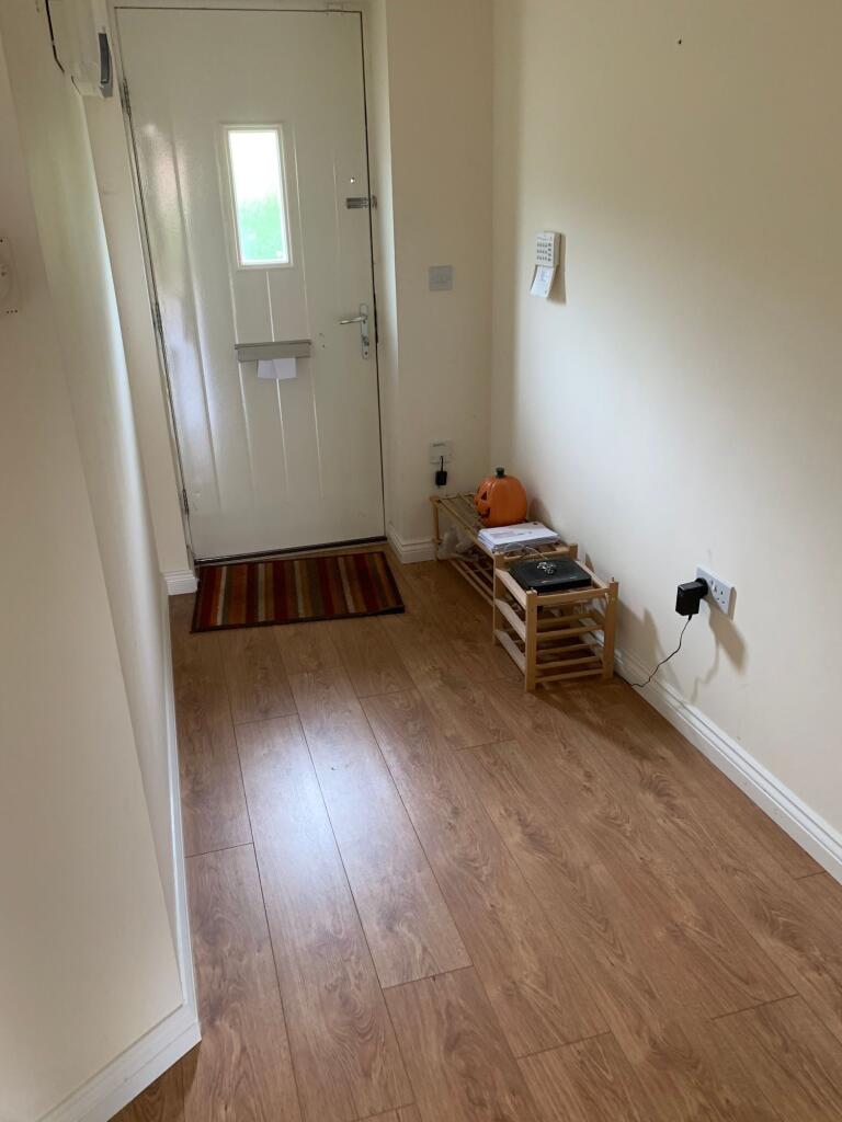 A neat and tidy hallway with light wooden floor...