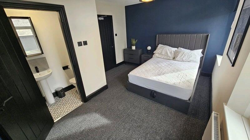 A clean and well-lit bedroom featuring a comfor...