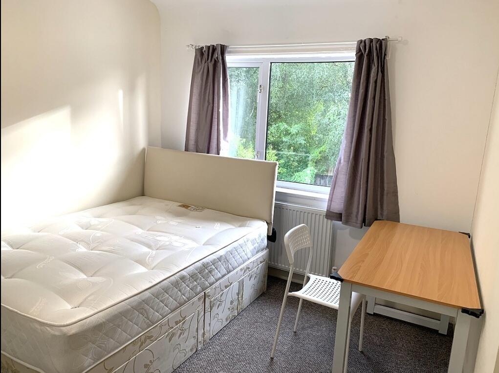 A clean and bright single bedroom featuring a c...