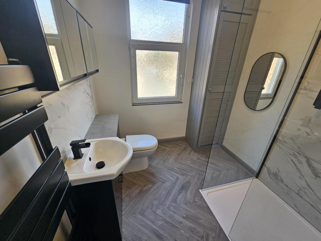 A clean and modern bathroom featuring a large s...