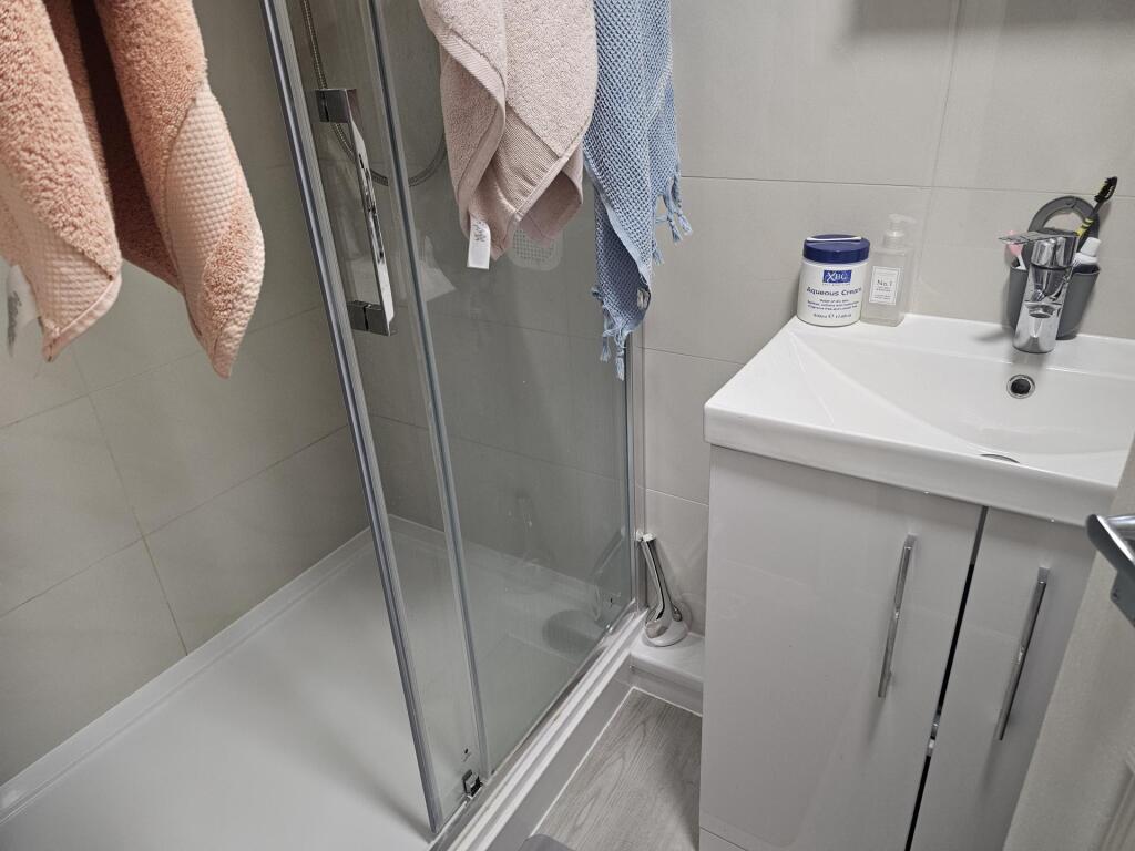 A modern bathroom featuring a glass-enclosed sh...