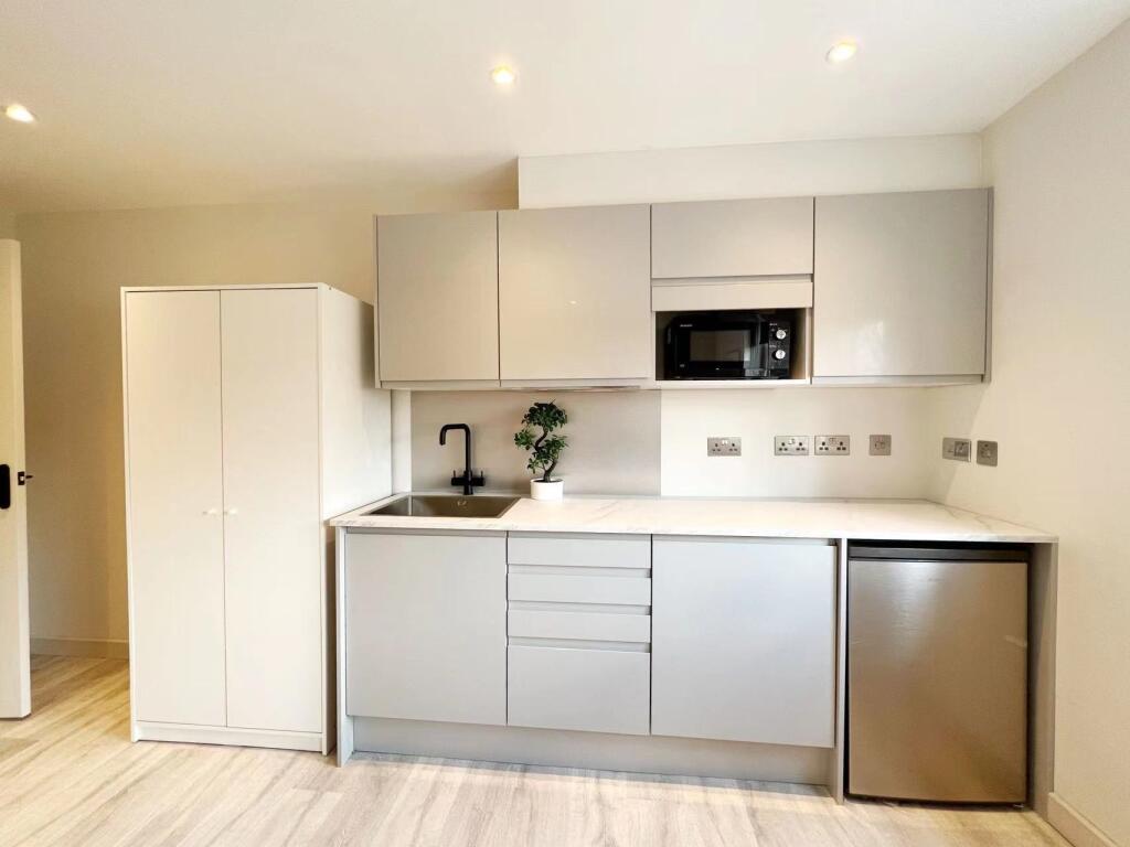 Modern and minimalist kitchen with sleek, light...