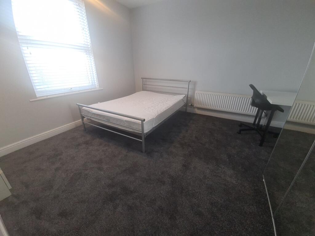 A spacious and clean bedroom featuring a double...
