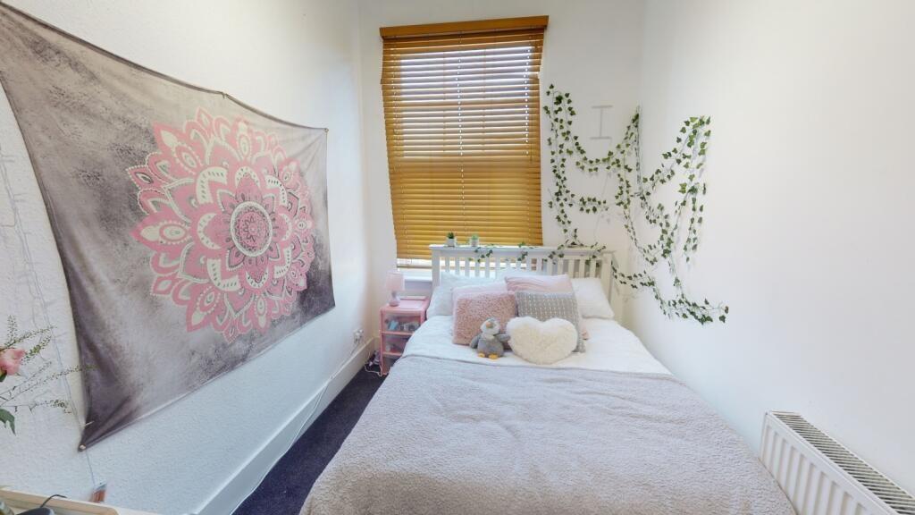 A cozy, well-kept single bedroom featuring a co...