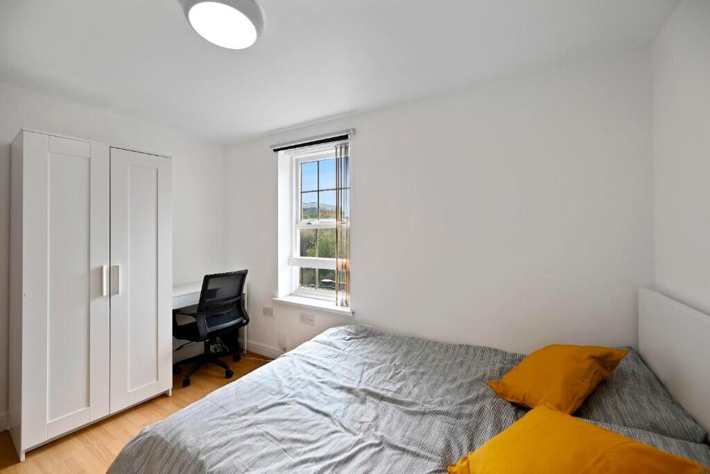 A bright and clean master bedroom featuring a c...