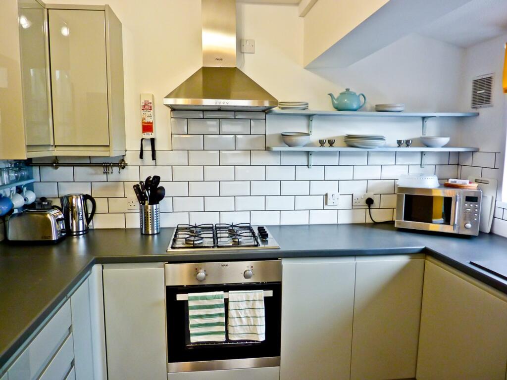 This modern kitchen features sleek cabinetry, a...