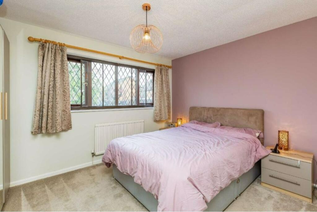 A cozy double bedroom featuring a large bed, so...