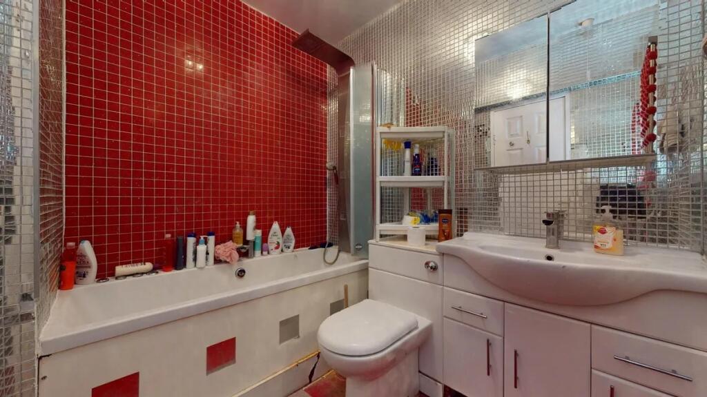 A modern bathroom suite featuring a white batht...