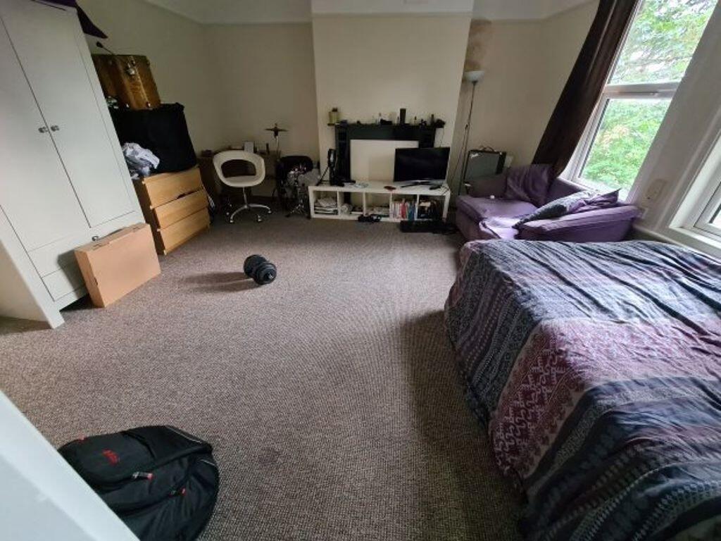 A spacious and well-lit bedroom featuring a lar...