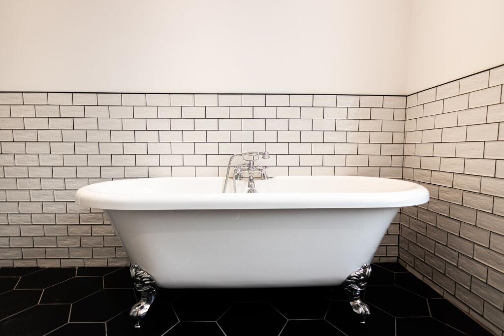 A spacious, elegant bathroom with a classic cla...
