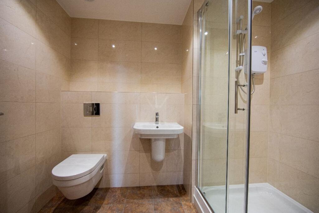 A modern bathroom suite featuring a walk-in sho...