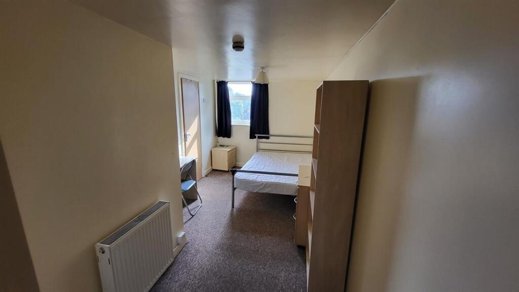A neat and simple single bedroom featuring a wi...