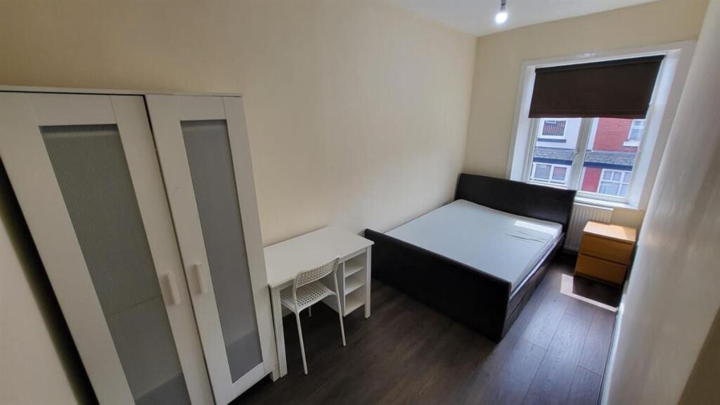 A bright and clean bedroom featuring a comforta...