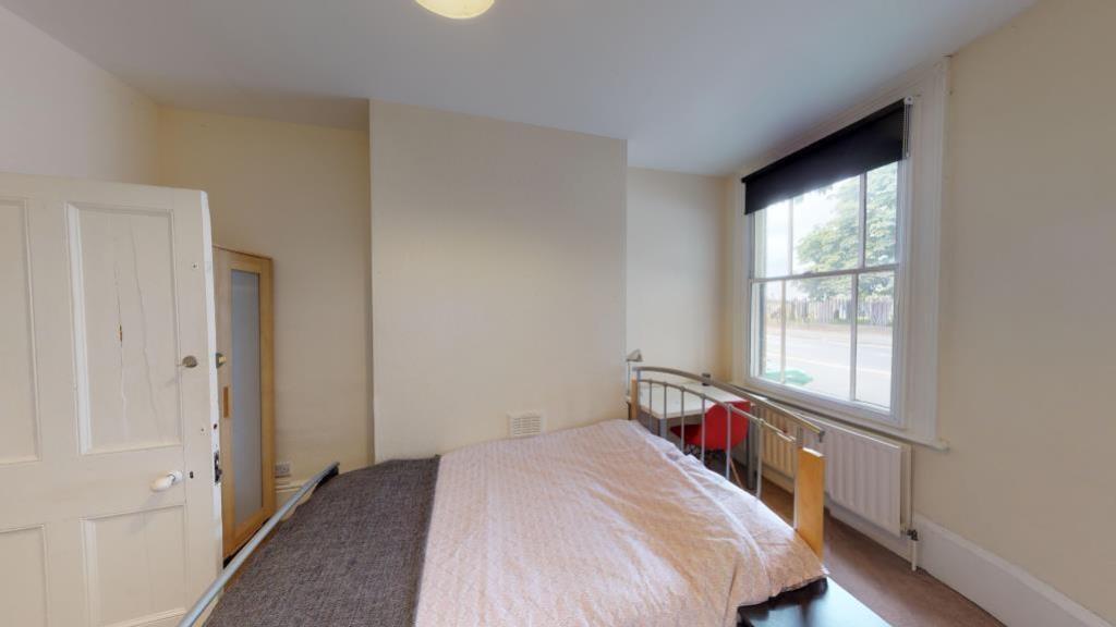 A bright and tidy double bedroom featuring a co...