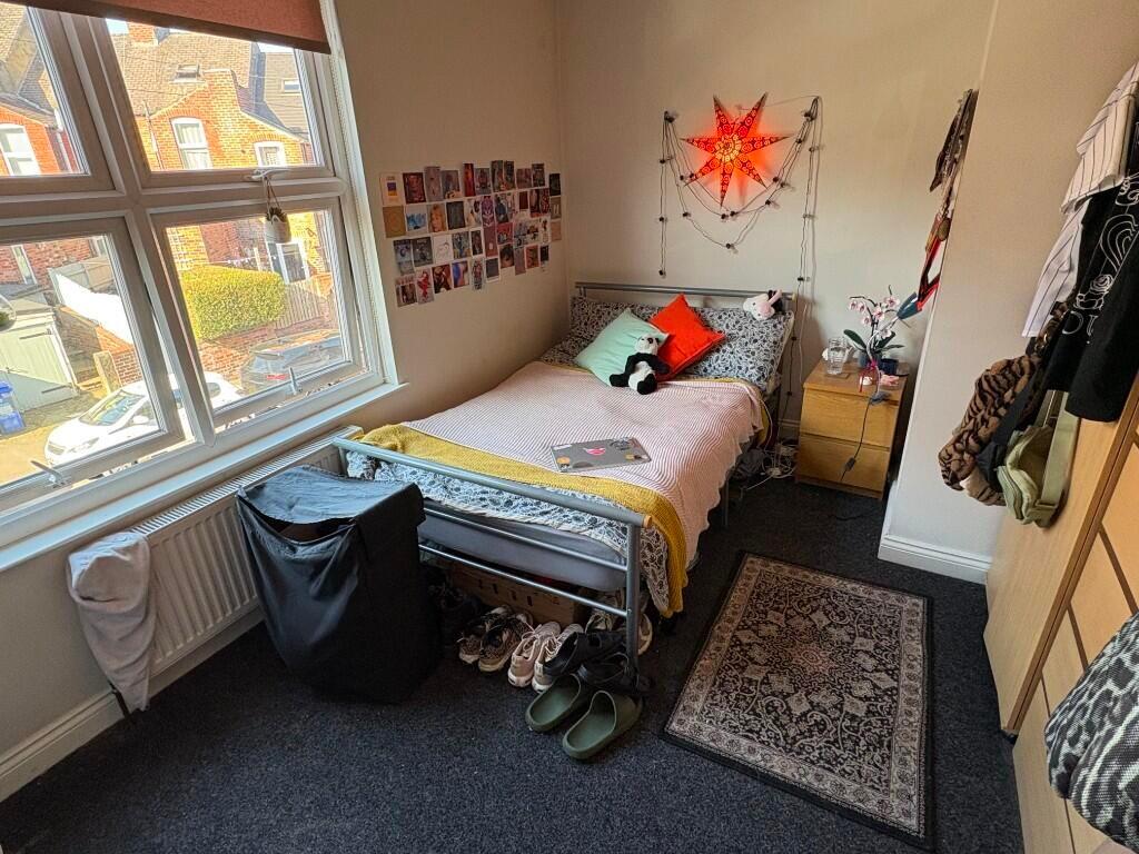 Bright and cozy single bedroom featuring a comf...