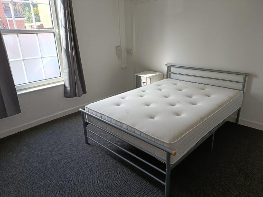 A bright double bedroom featuring a comfortable...