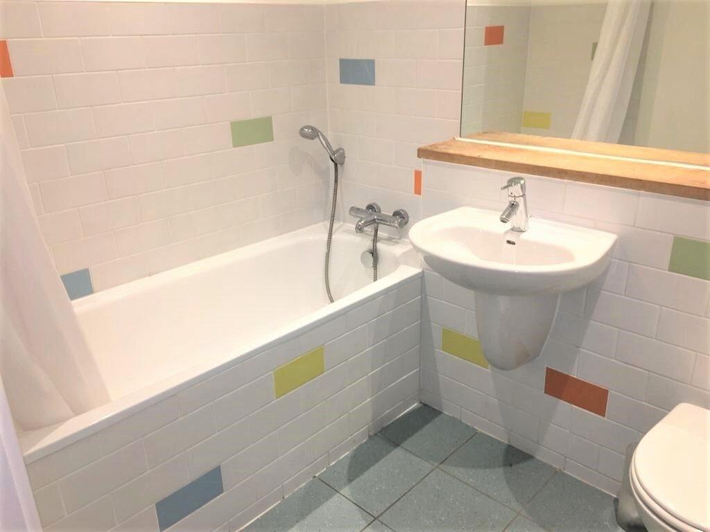Bright and clean bathroom suite featuring a spa...