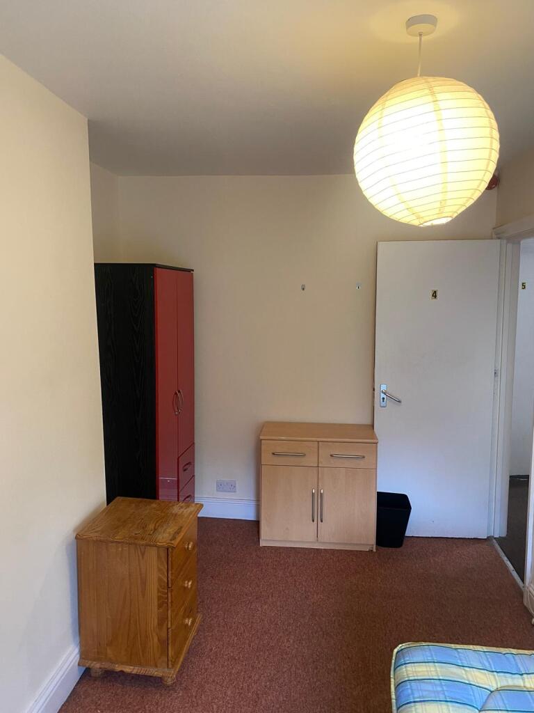 A simple, well-kept single bedroom featuring es...