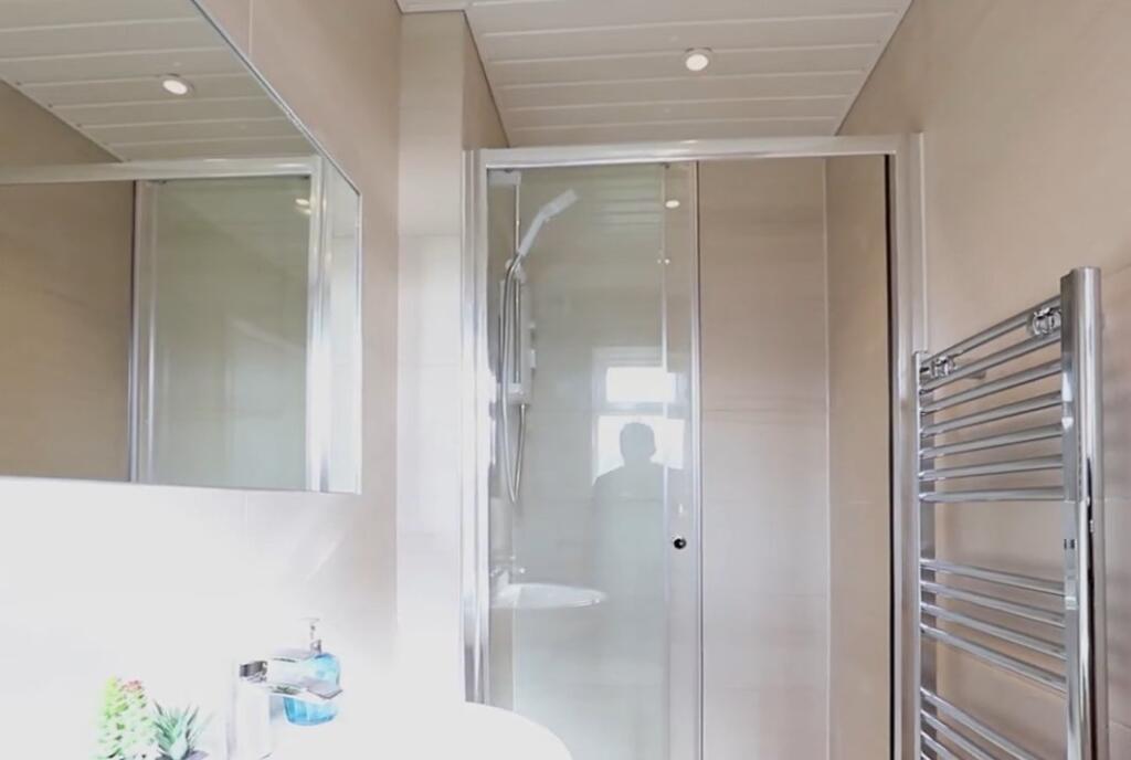 Bright and modern bathroom suite featuring a gl...