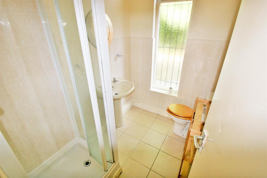 A bright bathroom featuring a spacious shower c...