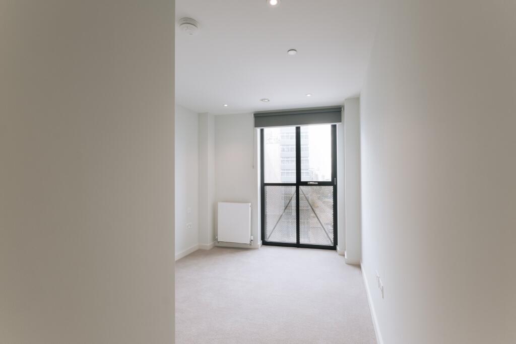 Experience tranquility in this spacious bedroom with a city view.