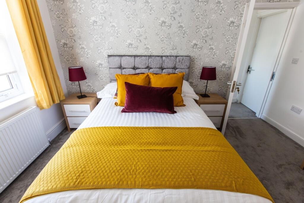 A tidy and well-lit double bedroom featuring ye...