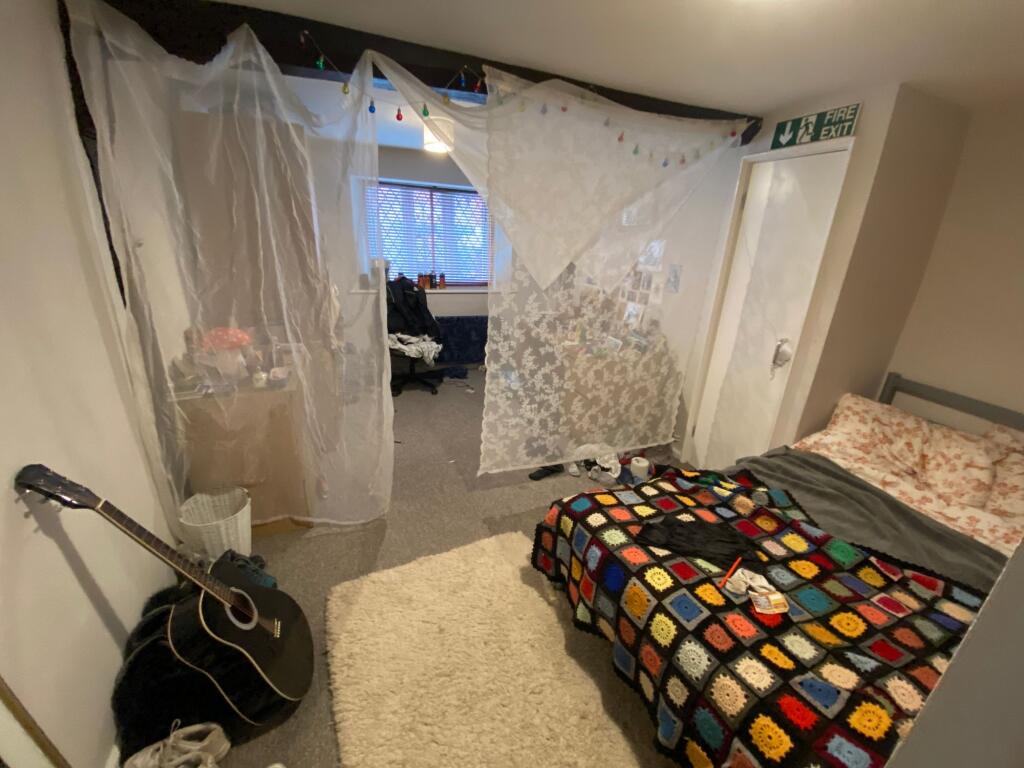 Cozy single bedroom featuring a comfortable bed...