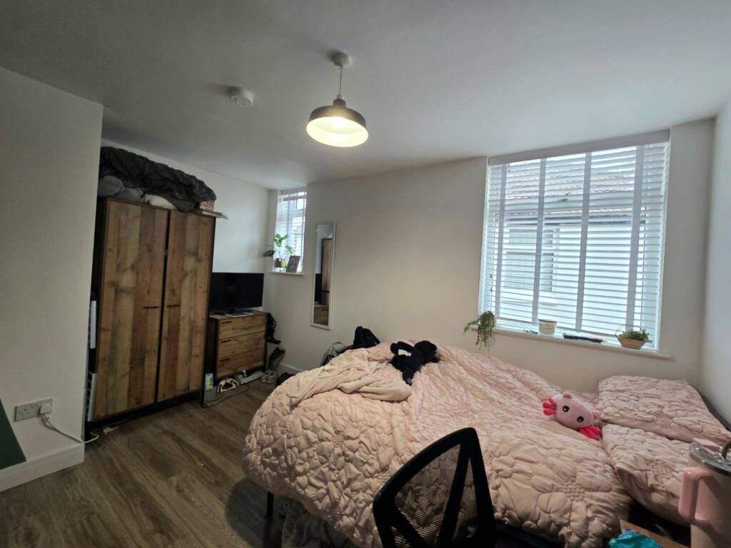 A cozy bedroom featuring a large window that al...