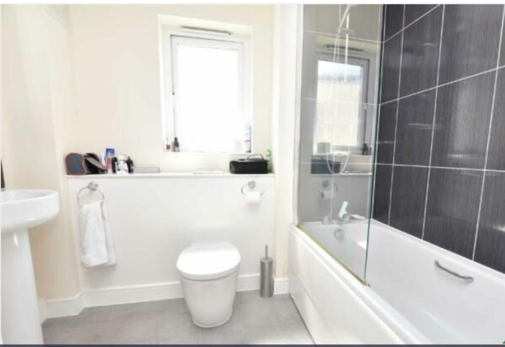 Bright and modern bathroom suite featuring a cl...