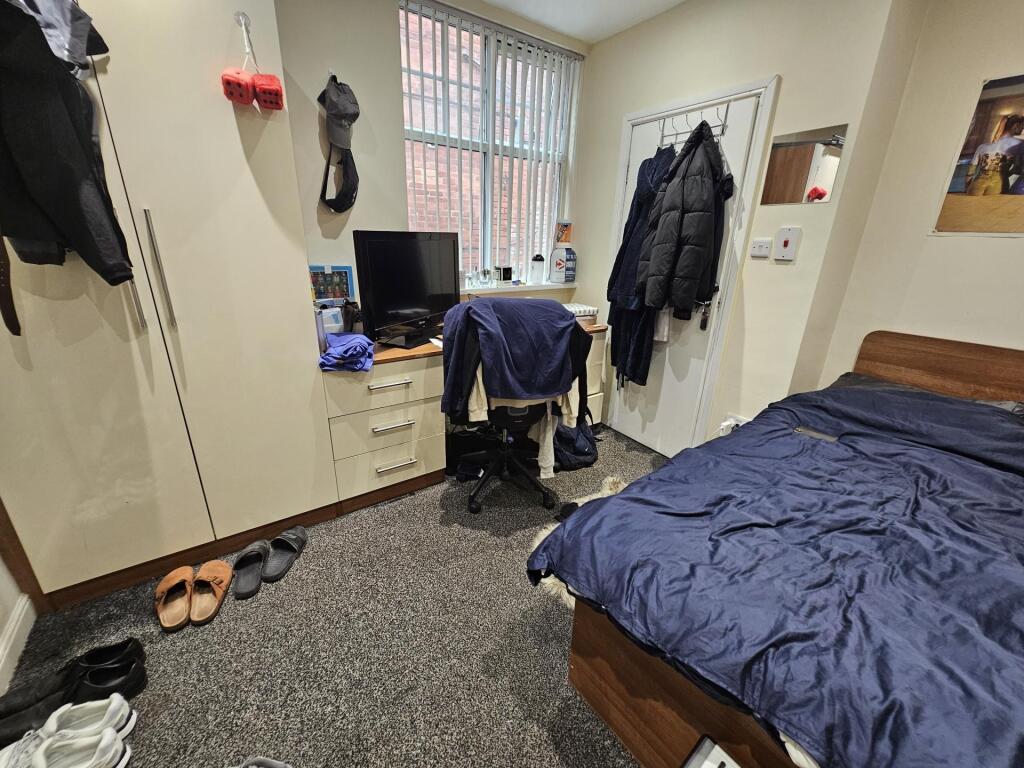 A cozy bedroom featuring a bed with a blue duve...