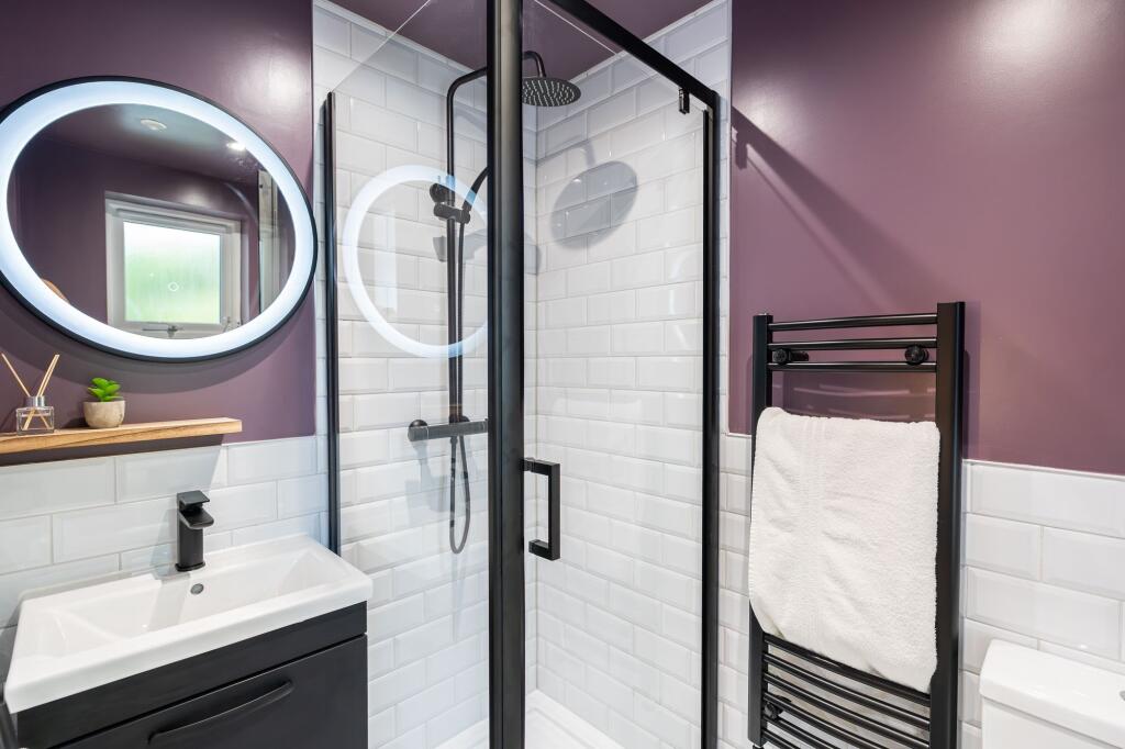 Modern bathroom with white tiled walls, a sleek...