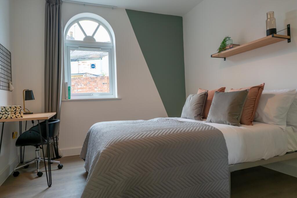 A bright and stylish double bedroom with a cozy...