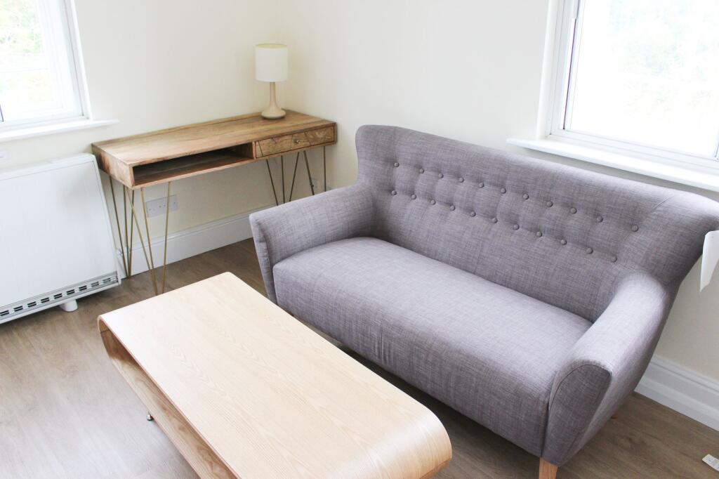 A bright and neat living area featuring a comfo...