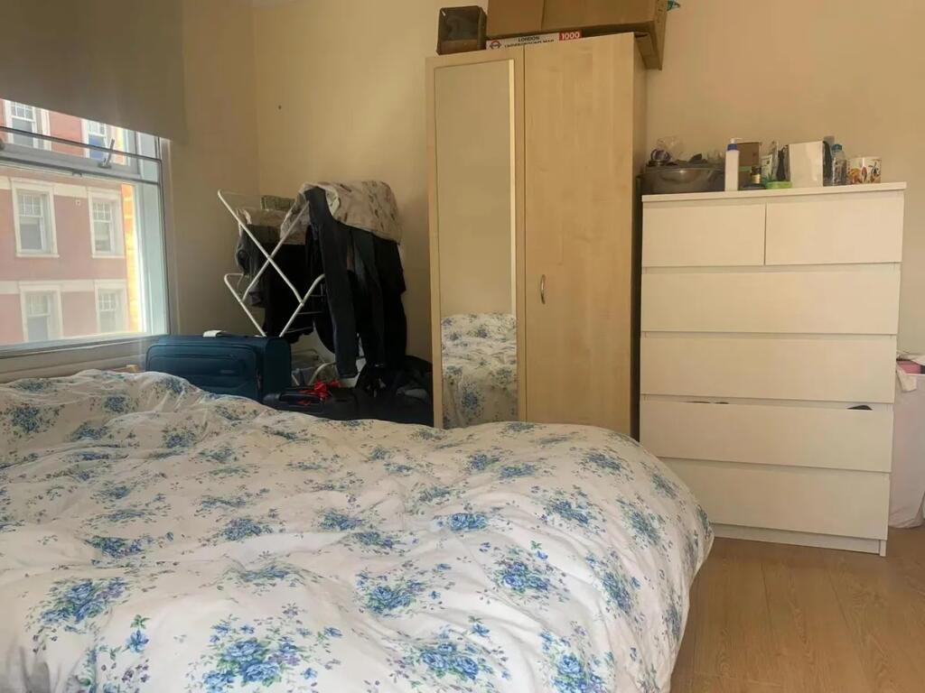 A cozy double bedroom featuring a large window ...