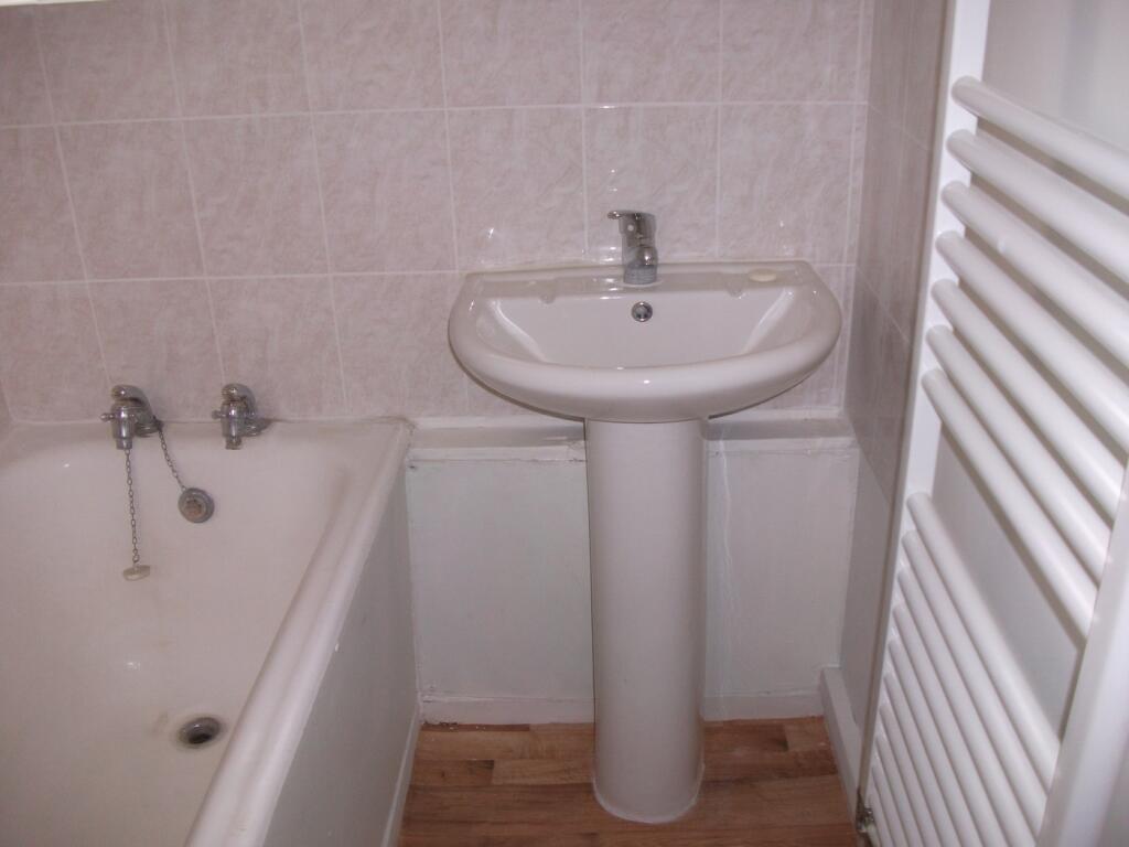 A tidy bathroom featuring a bath and sink, perf...