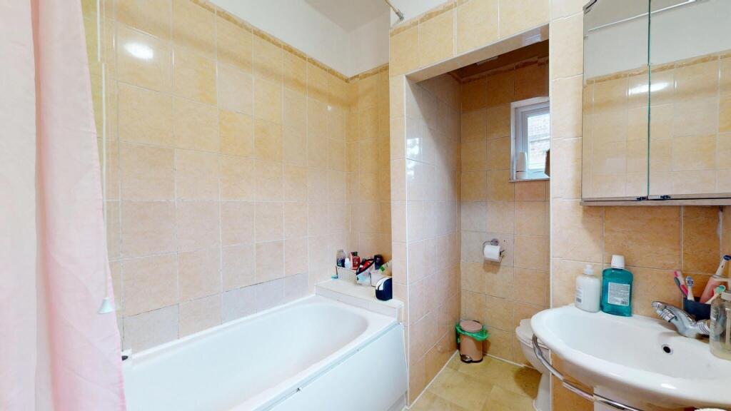 A bright and clean bathroom suite featuring a f...