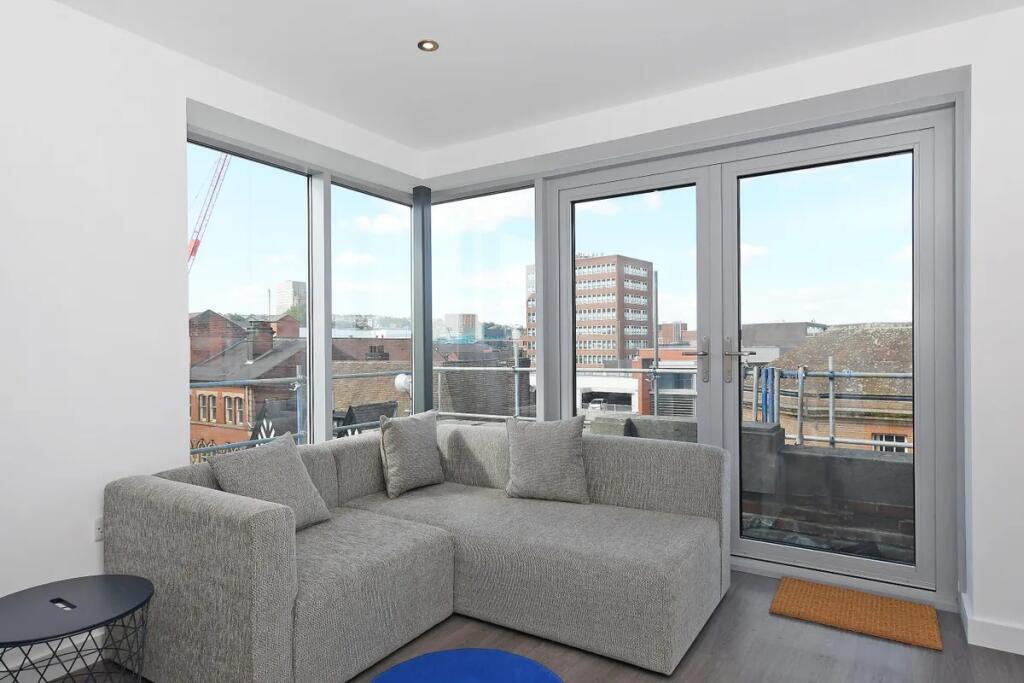 Bright and modern living room featuring a comfo...