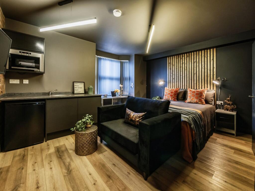 A stylish and modern master bedroom featuring a...