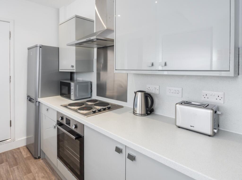 A modern and clean kitchenette equipped with es...