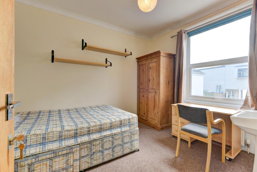 A bright and tidy single bedroom featuring a co...