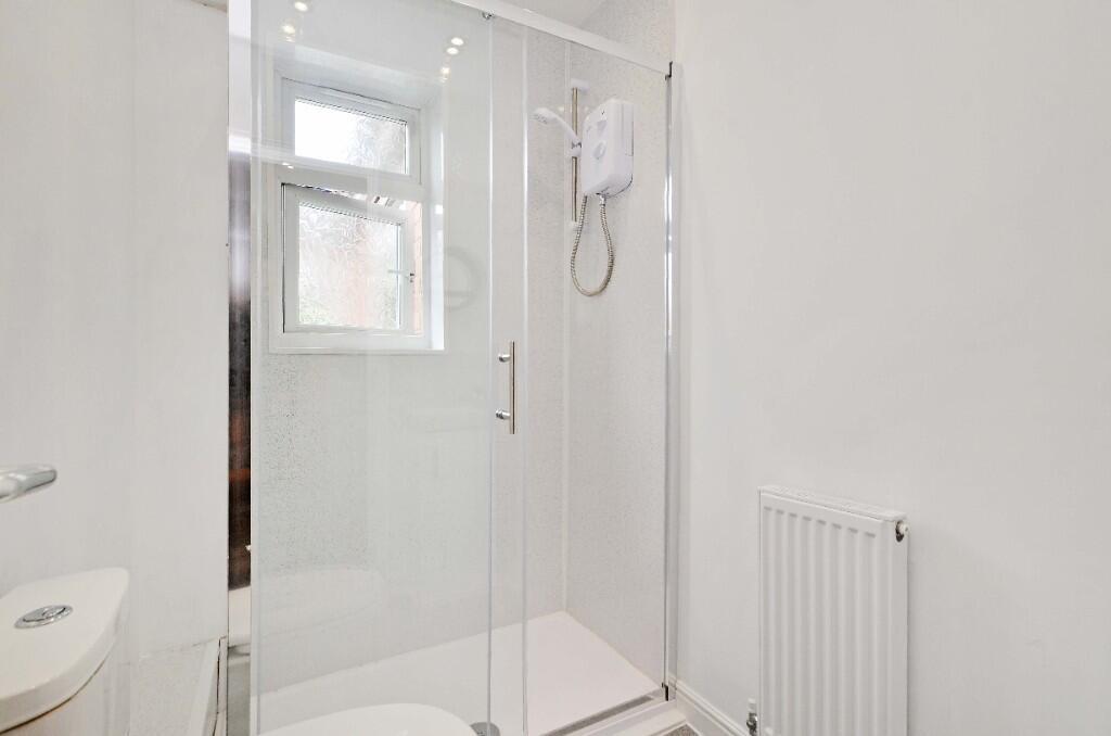 Bright and modern bathroom suite featuring a gl...