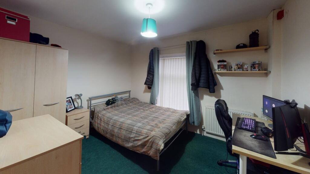 A cozy single bedroom featuring a neatly made b...