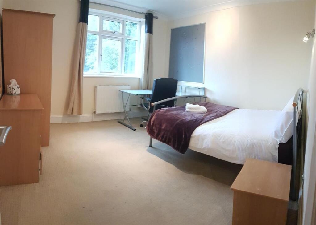 A bright and tidy single bedroom featuring a co...