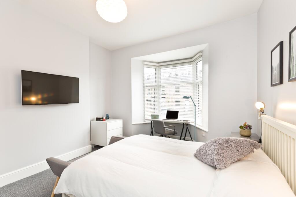 Bright and inviting spacious bedroom with a com...