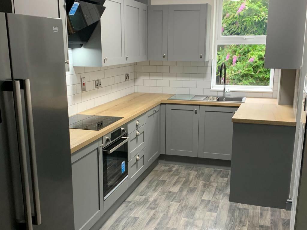 Modern kitchen with sleek grey cabinetry and li...